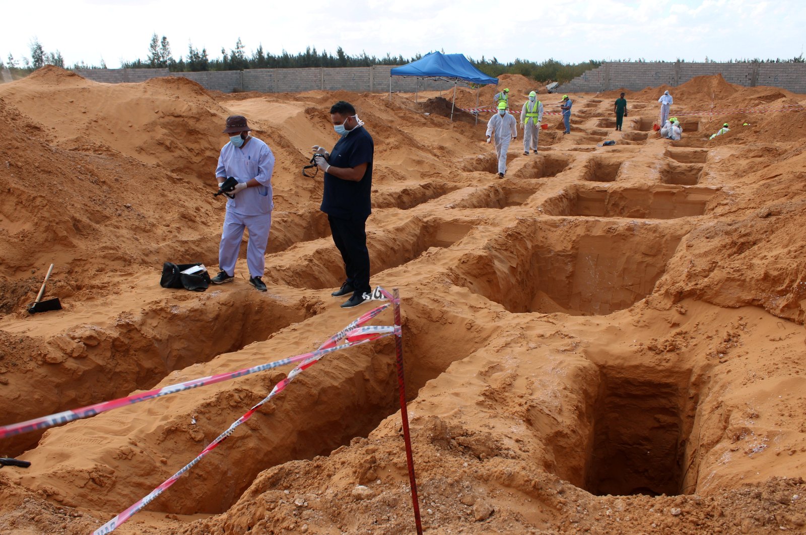 Members of the Government of National Accord's (GNA) missing persons bureau, gather to exhume bodies in a mass grave, in Tarhuna city, Libya, Oct. 27, 2020. (Reuters File Photo)