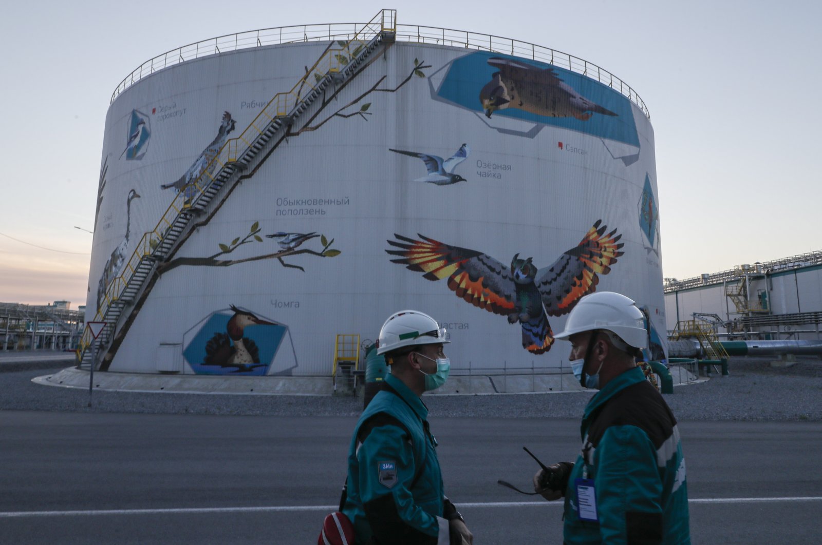 Workers stand in front of a huge water tank at one of the largest petrochemical complexes in the world 'ZapSibNeftekhimin' in Tobolsk, Tyumen region, Russia, Sept. 24, 2021. (EPA Photo)