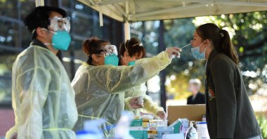 A young woman receives a COVID-19 rapid antigen test administer by a TLC Healthcare worker in Brighton, Melbourne, Australia, Oct. 14, 2021. (EPA Photo)