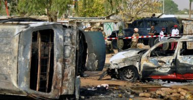 Police officers stand guard following a suicide bombing at a bus station in Kano, Nigeria, Feb. 24, 2015. (AP Photo)
