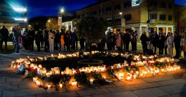 People lay flowers and light candles on the Stortorvet to honor the victims of the terrorist attack in Kongsberg, Norway, Oct. 14, 2021. (AFP Photo)