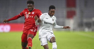 Bayern's Alphonso Davies (L) and Leverkusen's Jeremie Frimpong compete for the ball during a Bundesliga match at the Allianz Arena stadium in Munich, Germany, April 20, 2021. (AP Photo)