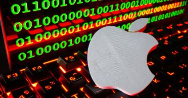 A 3D printed Apple logo is pictured on a keyboard in front of binary code in this illustration taken Sept. 24, 2021. (Reuters Photo)