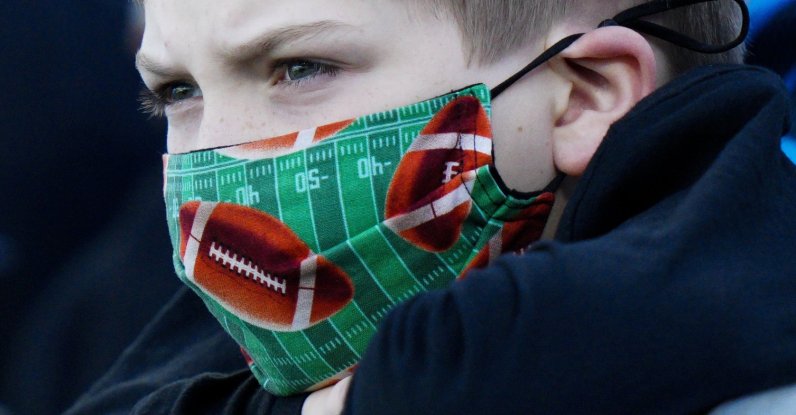 A fan wearing a football face mask watches during warm ups before an NFL football game between the Carolina Panthers and the Philadelphia Eagles, Oct. 10, 2021, in Charlotte, N.C. (AP Photo)