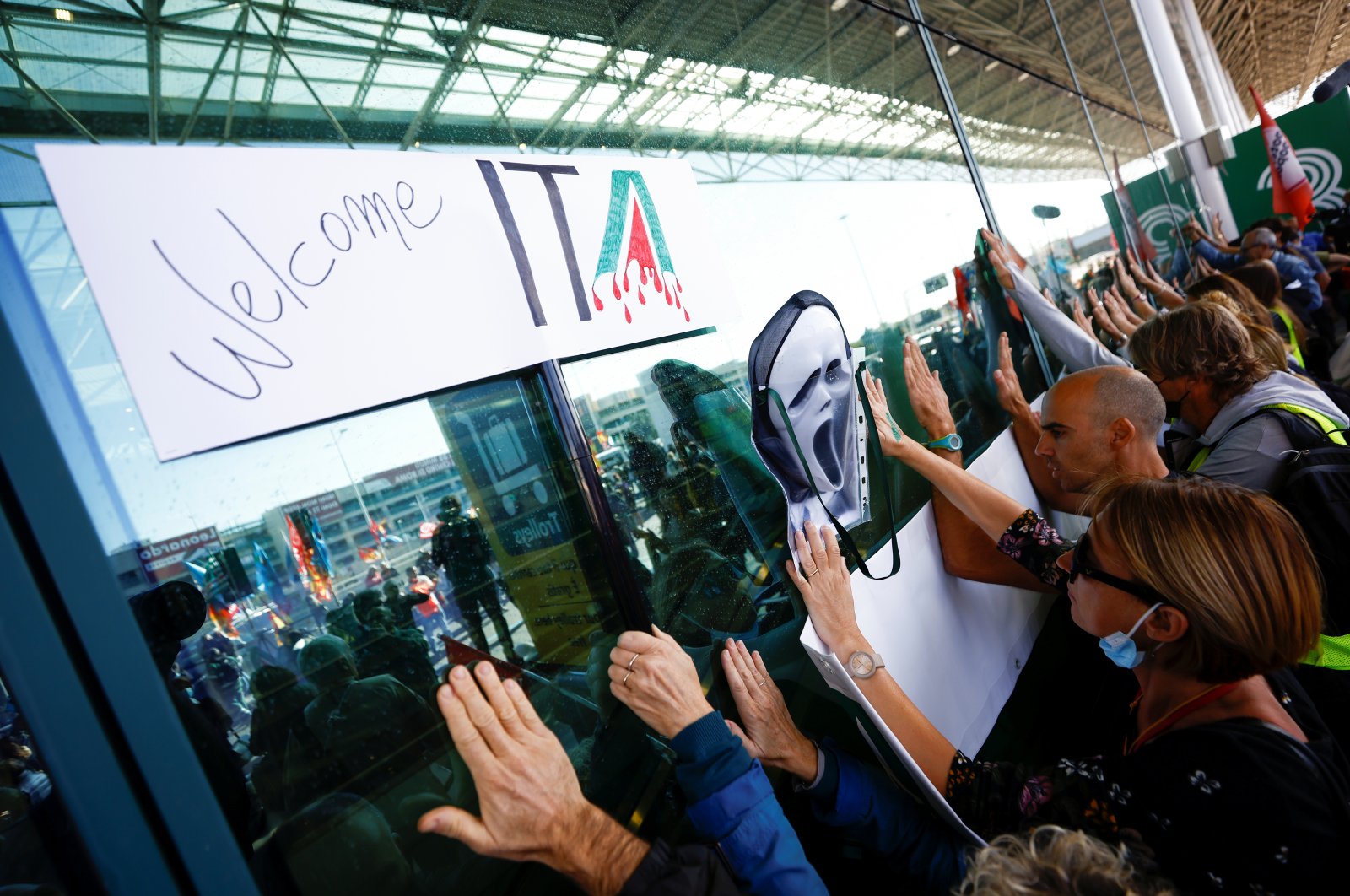 People gather outside Fiumicino airport as Alitalia workers protest against Italia Trasporto Aereo (ITA), as the new airline carrier starts flying in place of bankrupt Alitalia, in Rome, Italy, Oct. 15, 2021. (Reuters Photo)