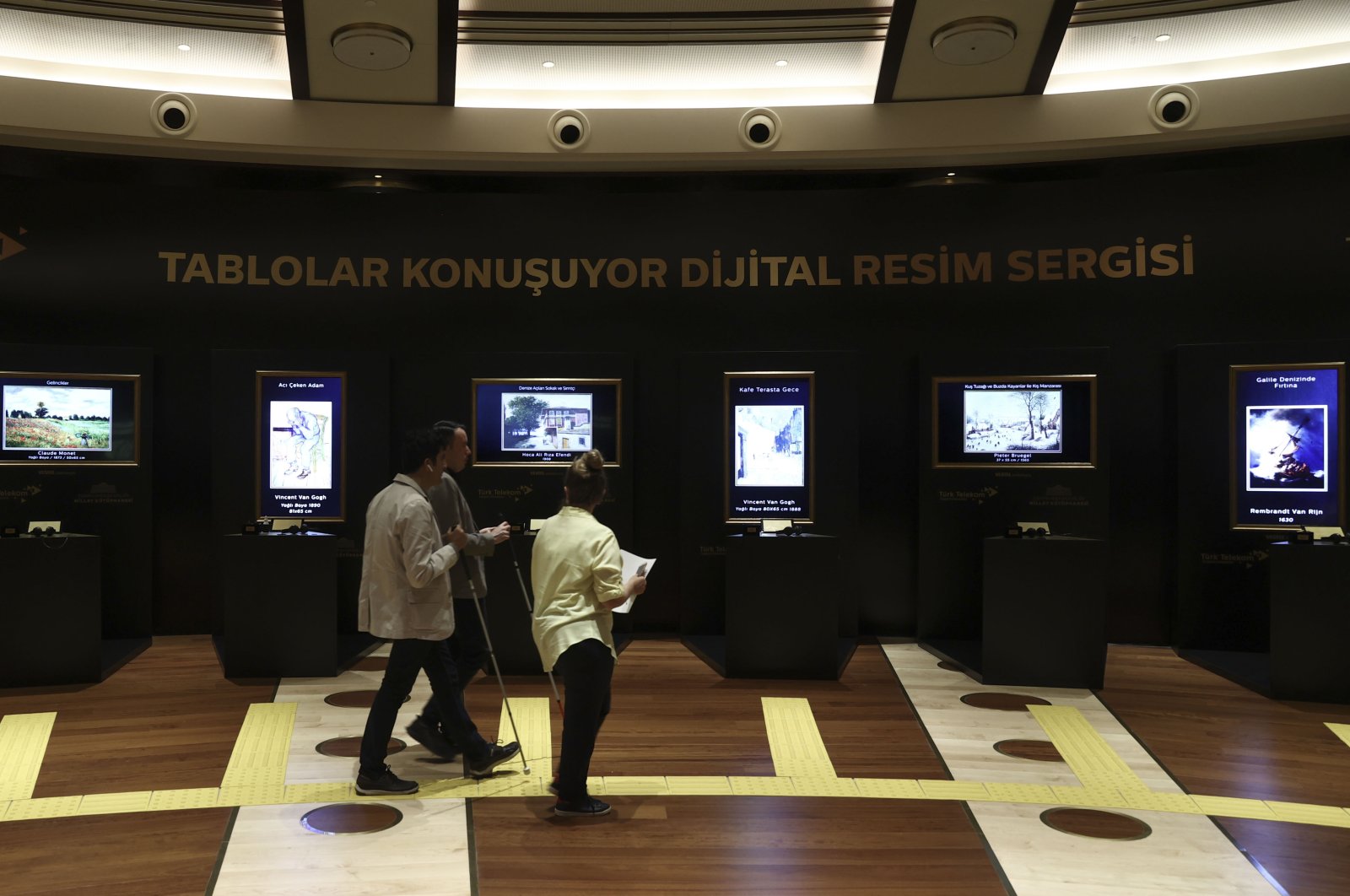 People visit the “Paintings Talk Digital Art Exhibition” at the Presidential Library within the scope of the 10th anniversary of Türk Telekom’s “Telephone Library” project that allows visually impaired people to access information and meet with art, Ankara, Turkey, July 30, 2021. (AA Photo)