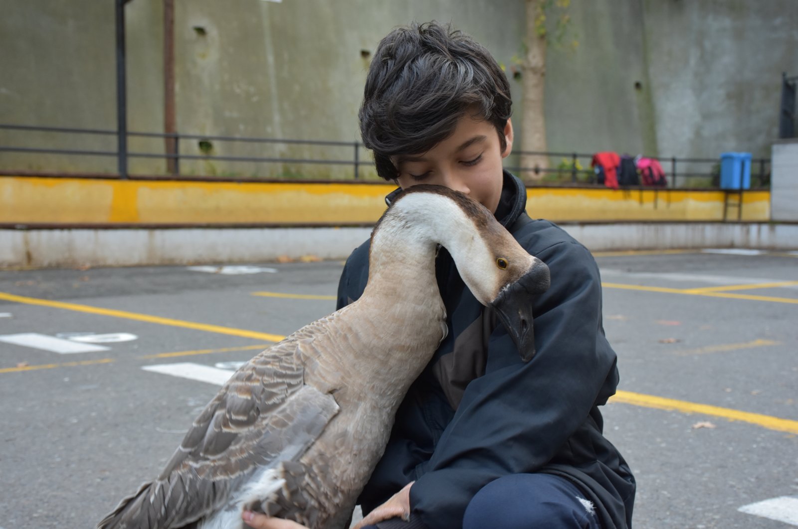 Thirteen-year-old Yiğit Terzi embraces his pet goose, Kirli, at his school in Trabzon, Turkey, Oct. 15, 2021. (AA Photo)