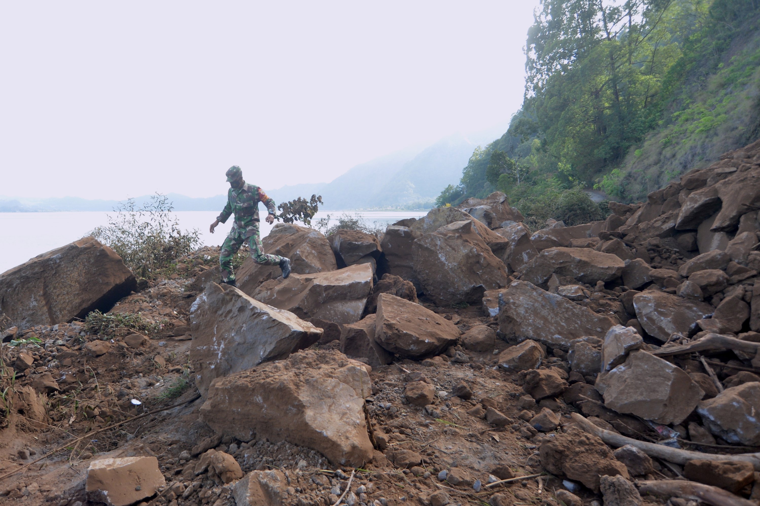 A member of Indonesian military walks through a landslide area after a 4.8 magnitude earthquake struck northeast of Bali, in Kintamani, Bali, Indonesia, Oct. 16, 2021. (Antara Foto/Fikri Yusuf/via Reuters)