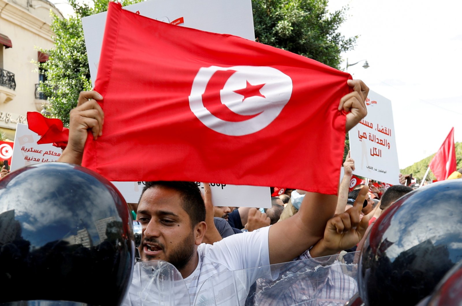 A demonstrator carries a Tunisian flag as he speaks with police during a protest against Tunisian President Kais Saied's seizure of governing powers, in Tunis, Tunisia, Oct. 10, 2021. (Reuters Photo)