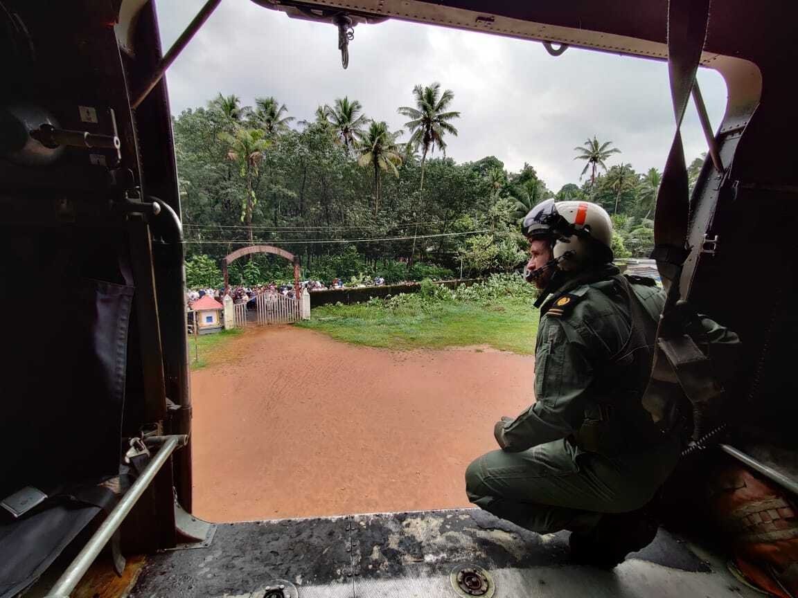 A navy person looking from their helicopter on a mission to distribute relief materials to flood-affected people at Koottickal in Kottayam district, southern Kerala state, India, Oct.17, 2021. (Indian Navy photo via AP)