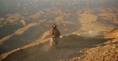 A Taliban member rides his motorbike on a hill in the Morghab district of Badghis province, Afghanistan, Oct. 15, 2021 (AFP Photo)