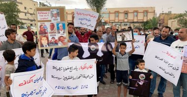 Families of victims hold signs as they demand justice for their missing ones and those found in mass graves, in Tarhuna, Libya, Oct. 9, 2021. (Reuters Photo)