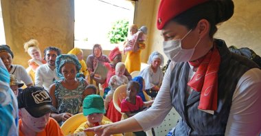 A Turkish Airlines employee distributes sunscreen to albino children, Dakar, Senegal, Oct. 17, 2021. (AA Photo)