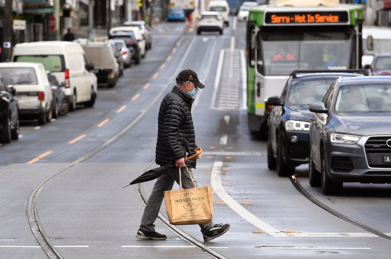 A man crosses a street in Melbourne on Oct. 11, 2021, during a lockdown against COVID-19 coronavirus as Sydney ended a 106-day lockdown. (AFP Photo)