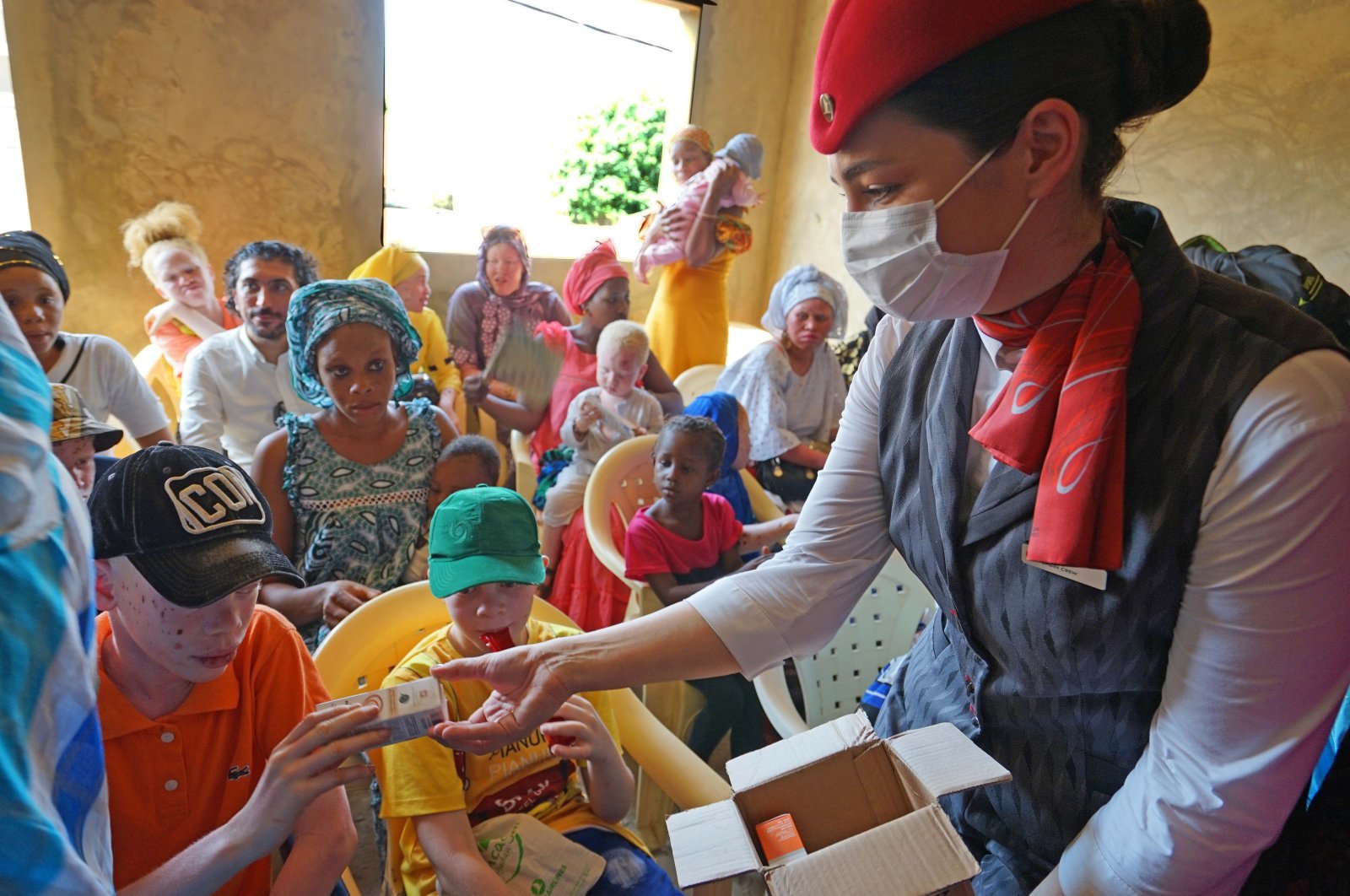 A Turkish Airlines employee distributes sunscreen to albino children, Dakar, Senegal, Oct. 17, 2021. (AA Photo)