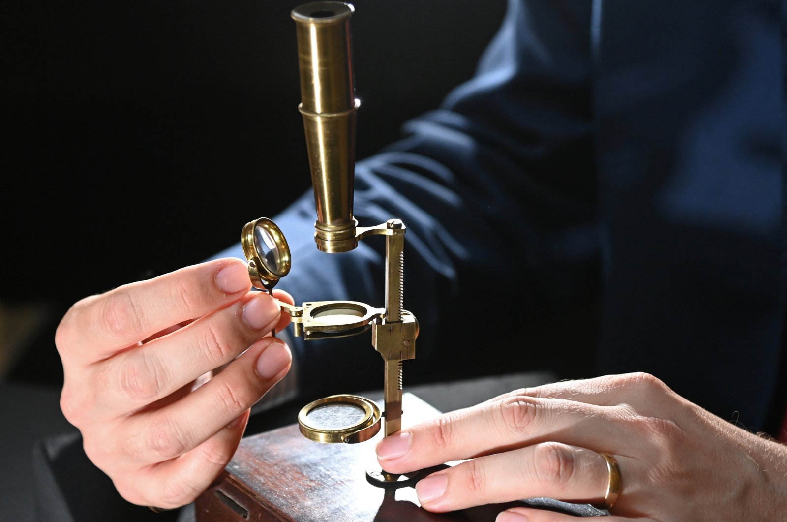James Hyslop, head of Scientific Instruments, Globes and Natural History at Christie's, demonstrates the Darwin Family Microscope, owned and used by the English naturalist and founder of the concept of evolution, Charles Darwin, which will be offered at auction as part of Christie's Classic Week, London, Britain, Oct.14, 2021. (Reuters Photo)
