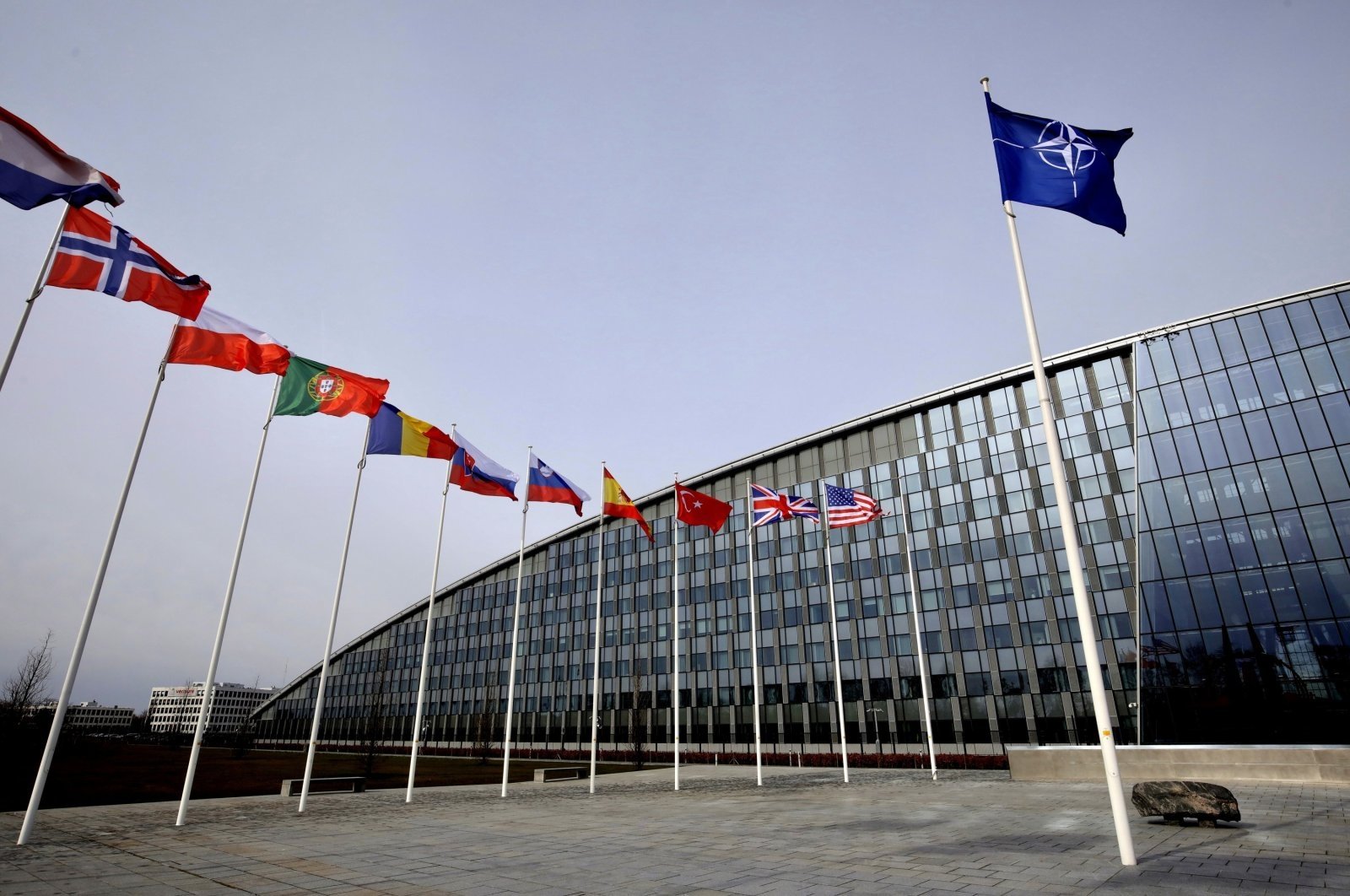 Flags of NATO alliance members flap in the wind outside NATO headquarters in Brussels, Belgium, Feb. 28, 2020. (AP Photo)