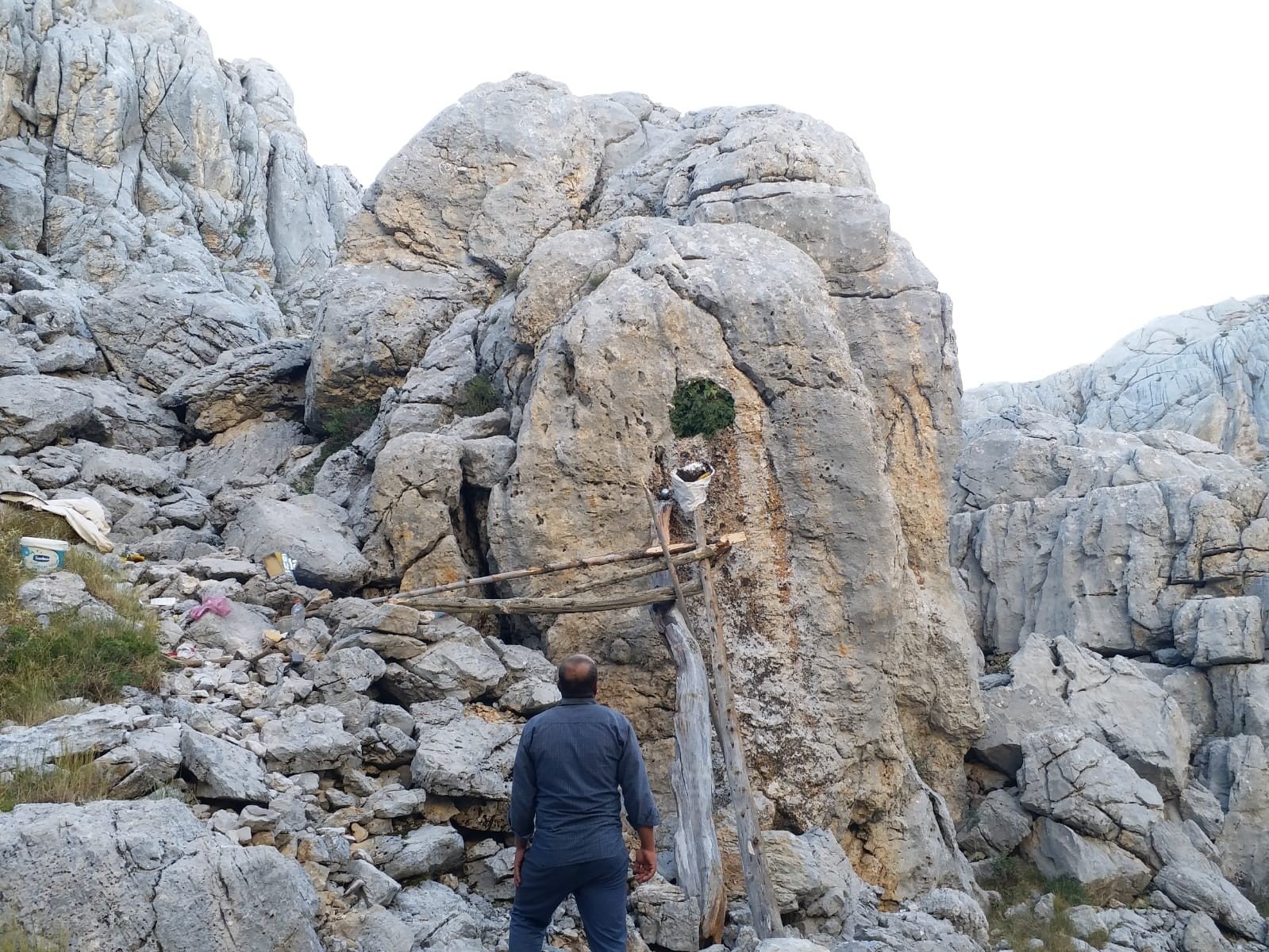 The beekeepers scale a rock face on makeshift scaffolding to extract honeycombs from a wild beehive in Antalya, southern Turkey, Oct. 17, 2021. (IHA Photo)