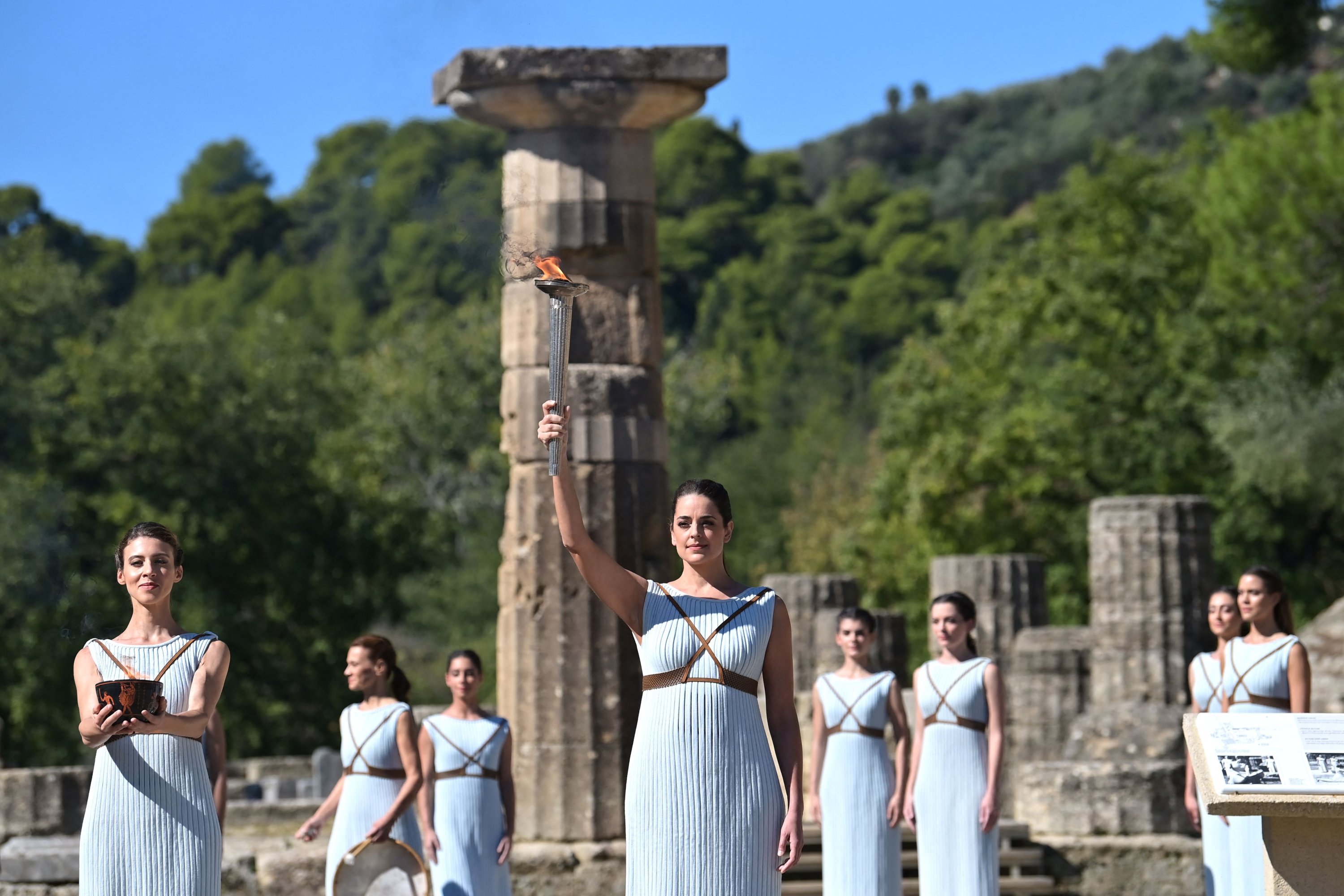 Greek actress Xanthi Georgiou (C), playing the role of the high priestess, holds up the lit torch during the flame lighting ceremony for the Beijing 2022 Winter Olympics at the Ancient Olympia archeological site, birthplace of the ancient Olympics in southern Greece, Oct. 18, 2021. (AFP Photo)