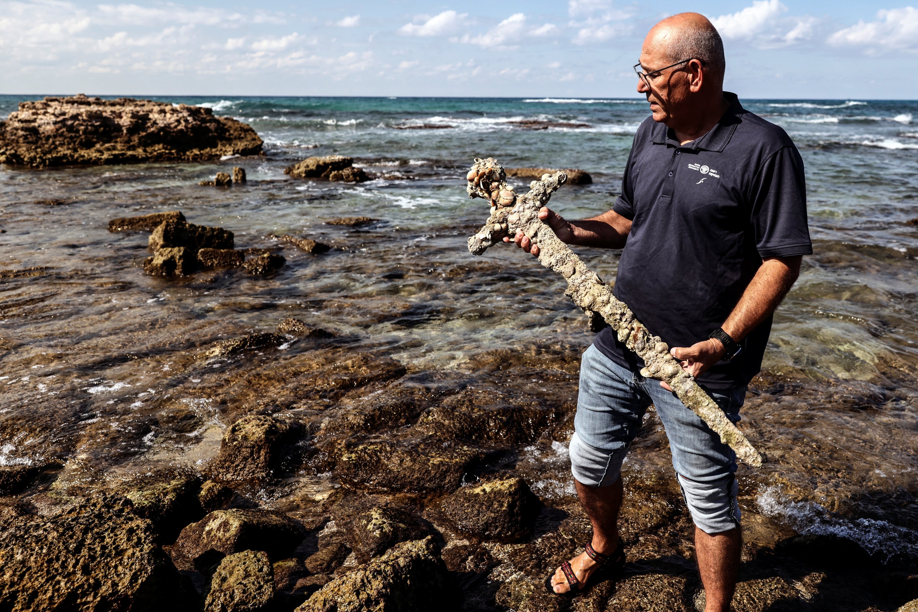 Yaakov Sharvit of the Israel Antiquities Authority holds the sword believed to have belonged to a Crusader, Caesarea, Israel, Oct. 18, 2021. (REUTERS Photo)