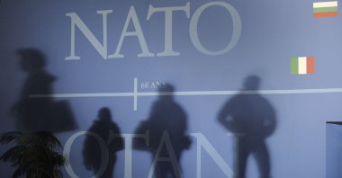 Attendees' shadows are cast on a wall decorated with the NATO logo and flags of NATO countries in Strasbourg, eastern France, April 2, 2009. (AFP File Photo)