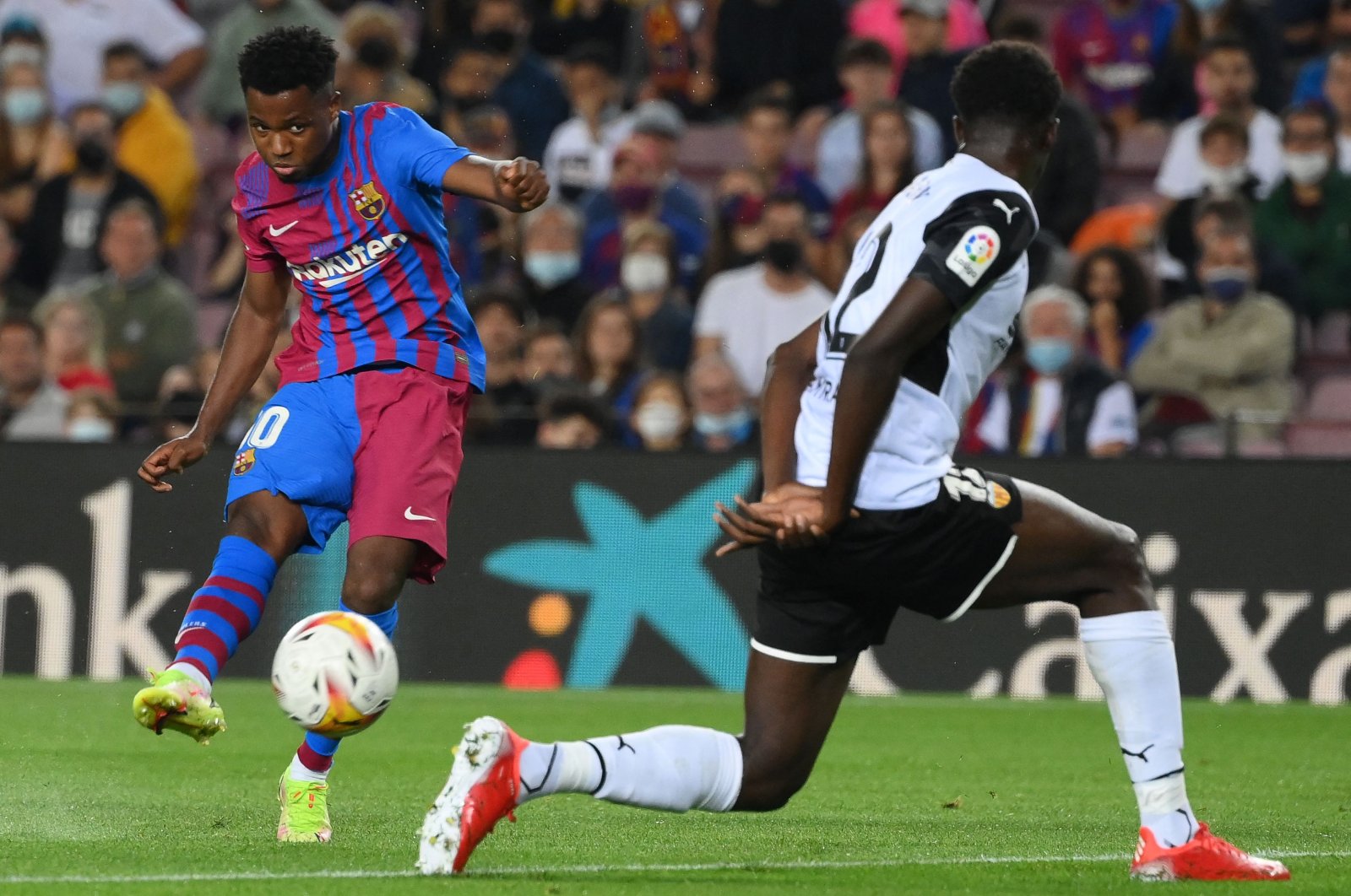 Barcelona's Spanish midfielder Ansu Fati (L) shoots to score his team's first goal in a La Liga match against Valencia at the Camp Nou, Barcelona, Spain, Oct. 17, 2021. (AFP Photo)