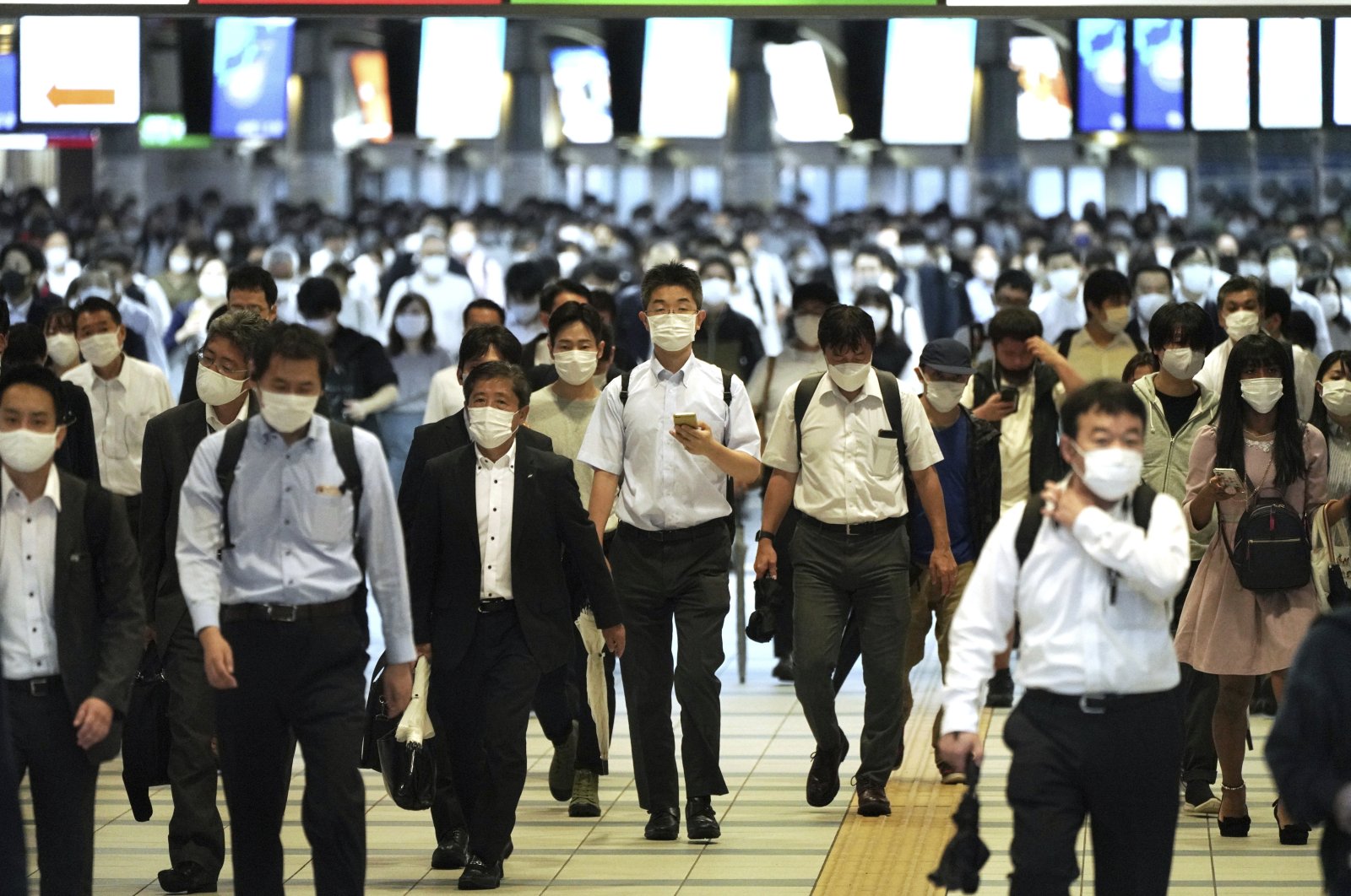 Commuters wearing face masks to help curb the spread of the coronavirus walk in a passageway during a rush hour at Shinagawa Station, in Tokyo, Japan, Oct. 1, 2021. (AP Photo)