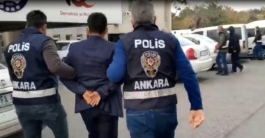 A suspect seen with police in capital Ankara, Turkey, Oct. 19, 2021. (DHA Photo)