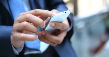 Close up of a man using a smartphone. (Shutterstock Photo)