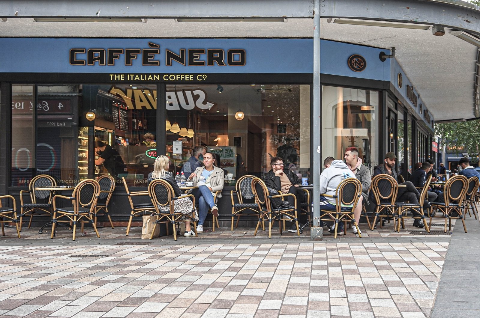Customers relax outside a Caffe Nero coffee shop, in Fountain Street, Britain, Aug. 22, 2021. (Reuters Photo)