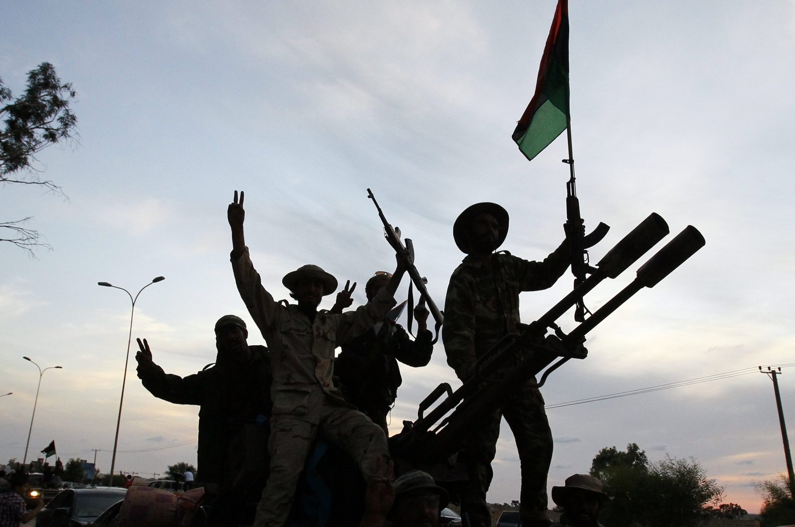 Libyan revolutionary fighters returning from Sirte are welcomed at Al Guwarsha gate in Benghazi, Libya, Oct. 22, 2011. (AP Photo)