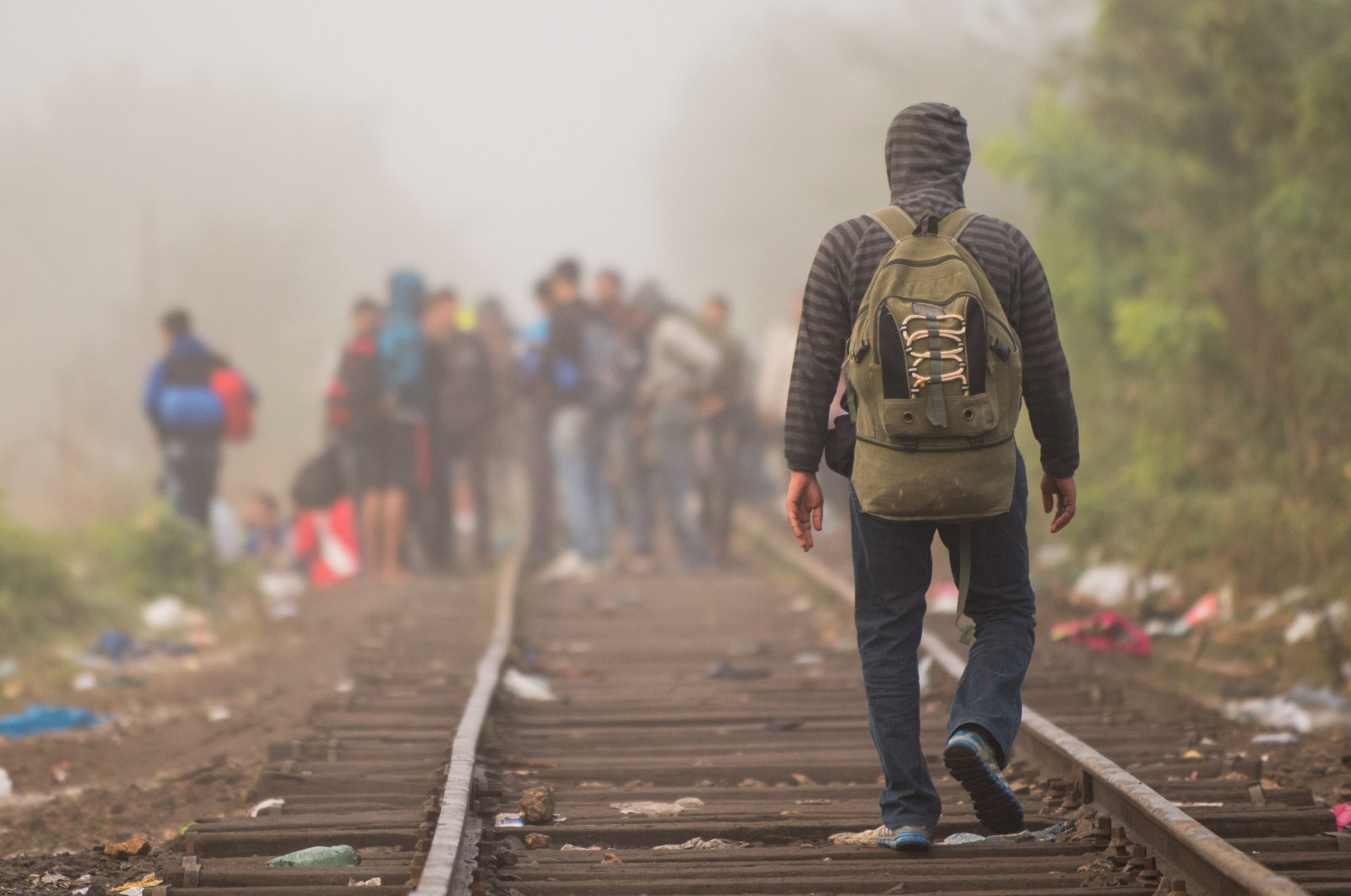 A man walks along a railway track after crossing the border between Serbia and Hungary in Roszke, southern Hungary, Sept. 12, 2015. (AP Photo)