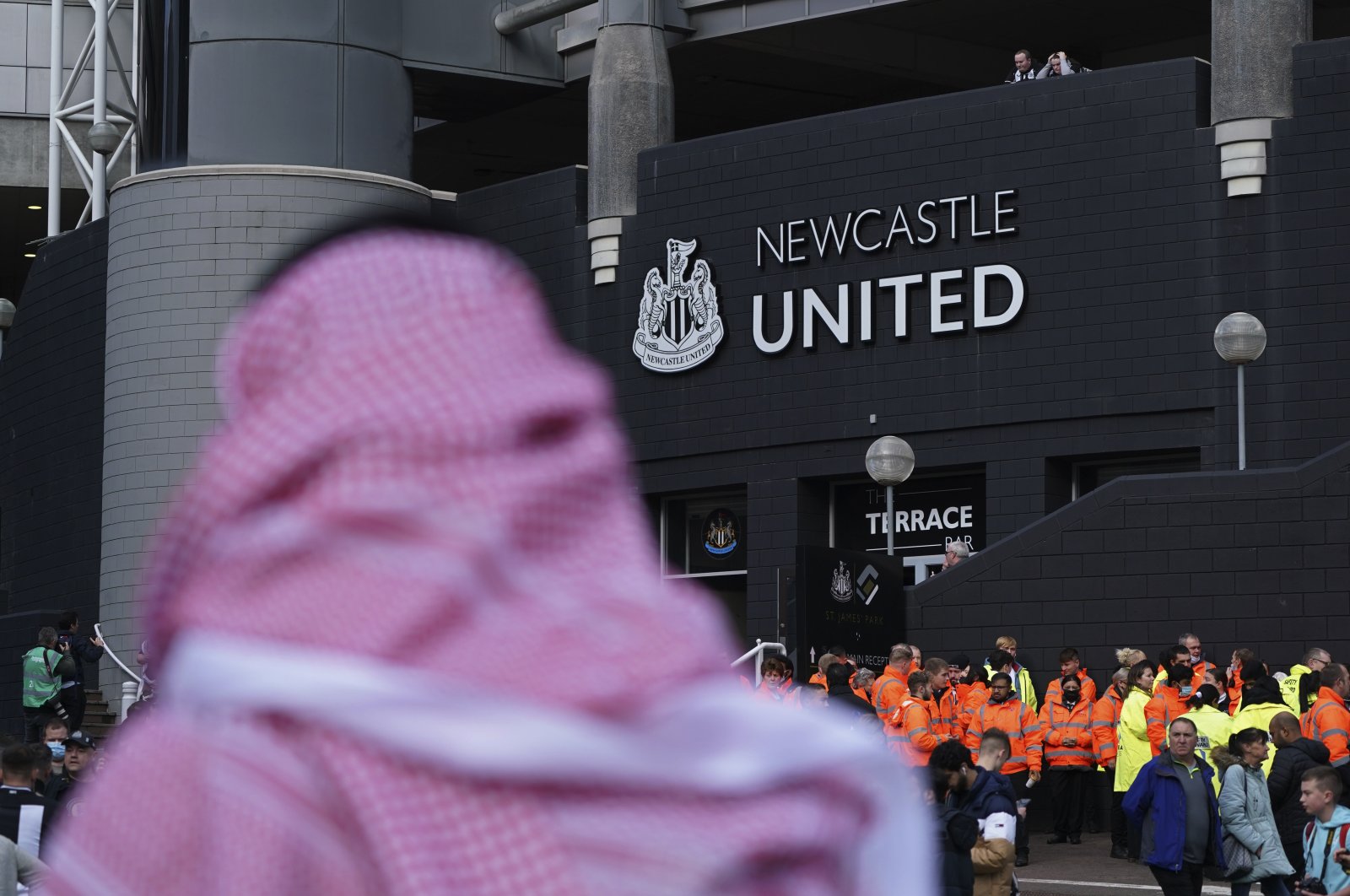 A man wearing a Saudi Arabian headdress passes the St. James' Park in Newcastle, England, Oct. 17, 2021. (AP Photo)