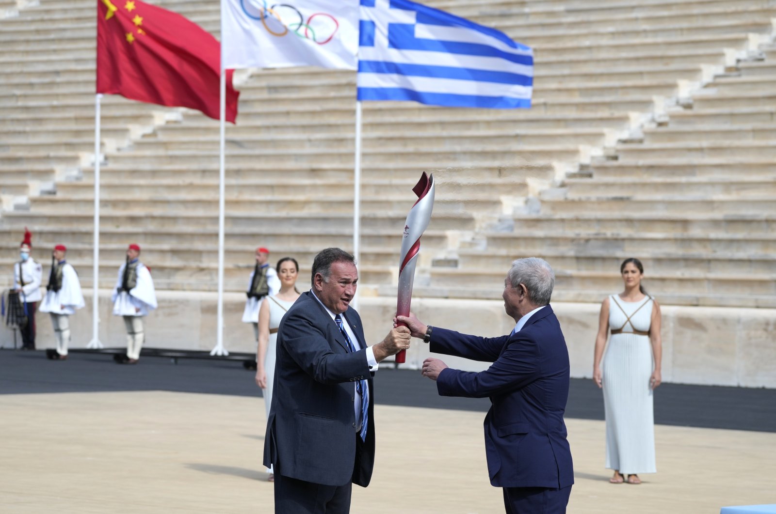 The Greek Olympic Committee chief Spyros Kapralos (L) hands over the Olympic flame to the Chinese Olympic Committee's Yu Zaiqing at Panathinean stadium in Athens, Greece, Oct. 19, 2021. (Reuters Photo)