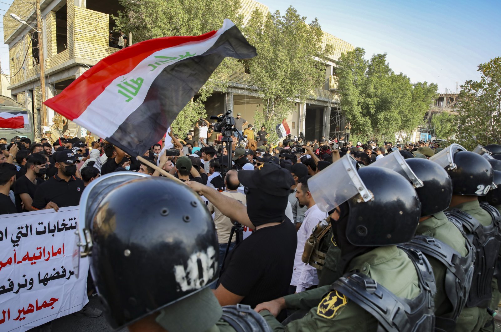 Security forces prevent protesters denouncing election results from storming the Electoral Commission building during a protest in Basra, Iraq, Oct. 19, 2021. (AP Photo)