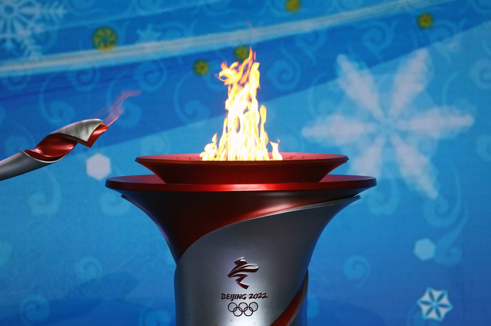 The Olympic flame is transferred from a torch to a cauldron at the ceremony to welcome the flame for the Beijing 2022 Winter Olympics, Beijing, China, Oct. 20, 2021. (Reuters Photo)
