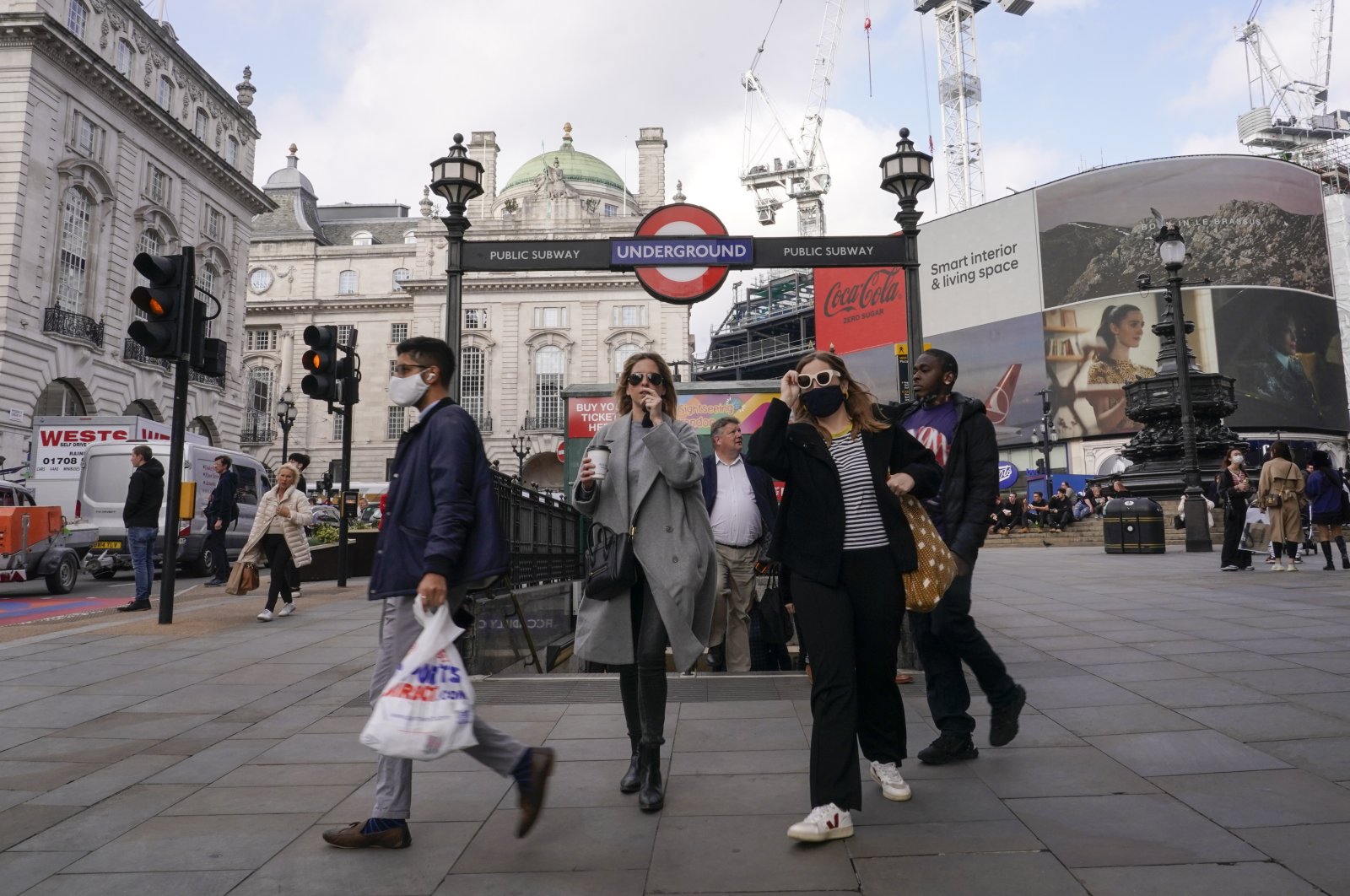 People wear face masks as they exit Piccadilly Circus underground station, in London, U.K., Oct. 19, 2021. (AP Photo)