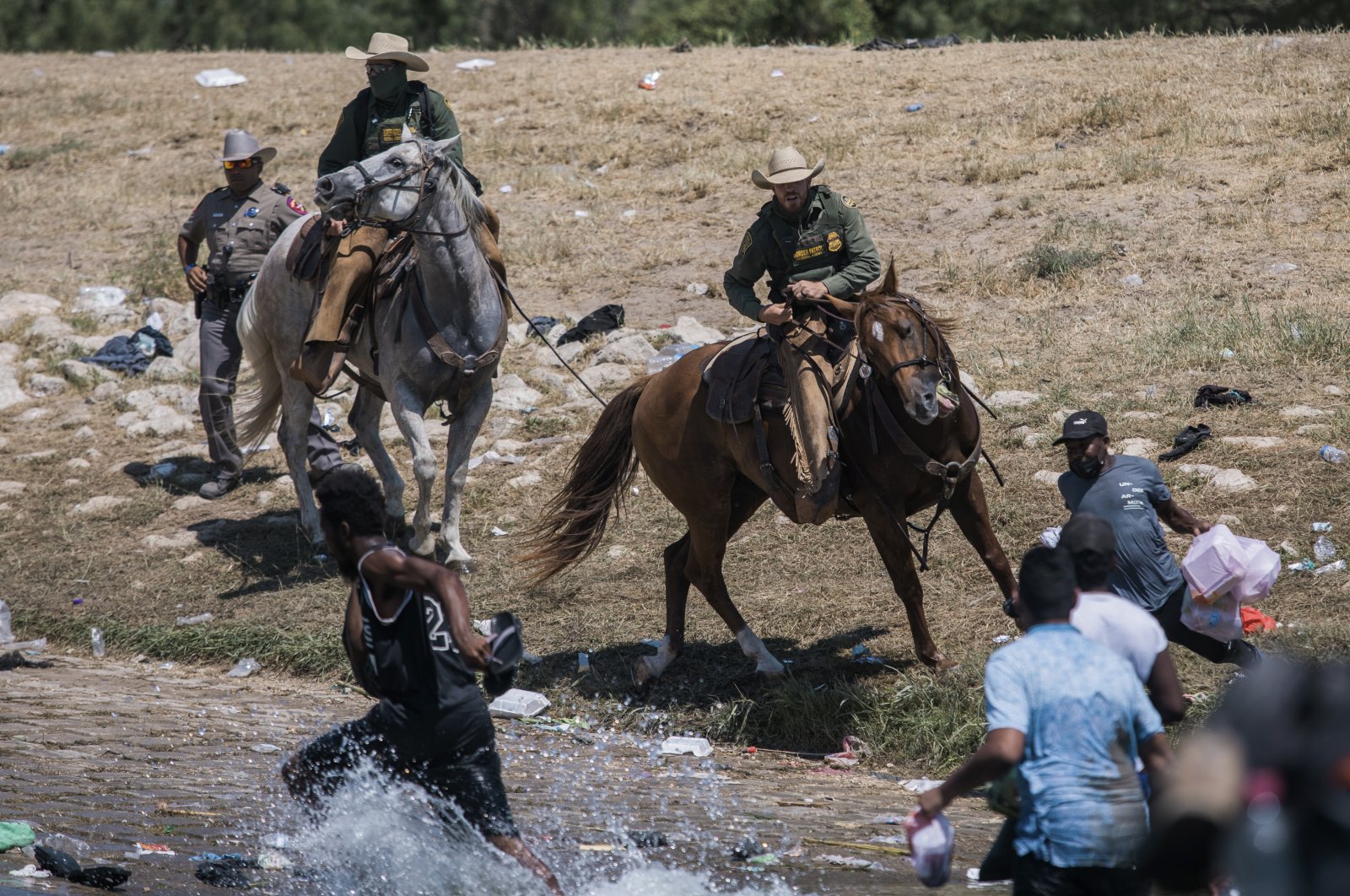 U.S. Customs and Border Protection mounted officers attempt to contain migrants as they cross the Rio Grande from Ciudad Acuna, Mexico, into Del Rio, Texas, U.S., Sept. 19, 2021. (AP Photo)