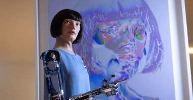 Ai-Da stands in front of one of "her" artworks during "Ai-Da: The World's First Robot Artist" press view at Design Museum in London, U.K., May 18, 2021. 
(Getty Images)