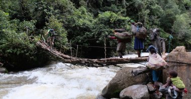 Rini Indyastuti’s porter brings the climbers food and equipment across the Kemabu River in the Intan Jaya Regency, Papua, Indonesia, June 2016. (Photo by Rini Indyastuti)