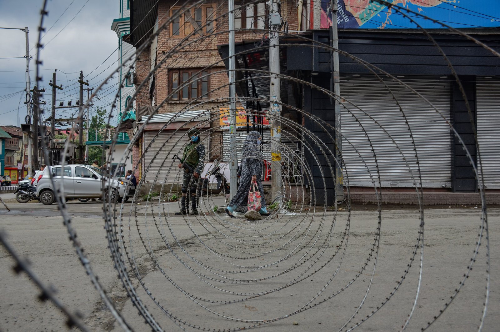 A woman walks past a barricade erected by Indian forces during restrictions imposed on the eve of Martyrs Day in the old city of Srinagar, Kashmir, July 13, 2021. (Photo by Getty Images)