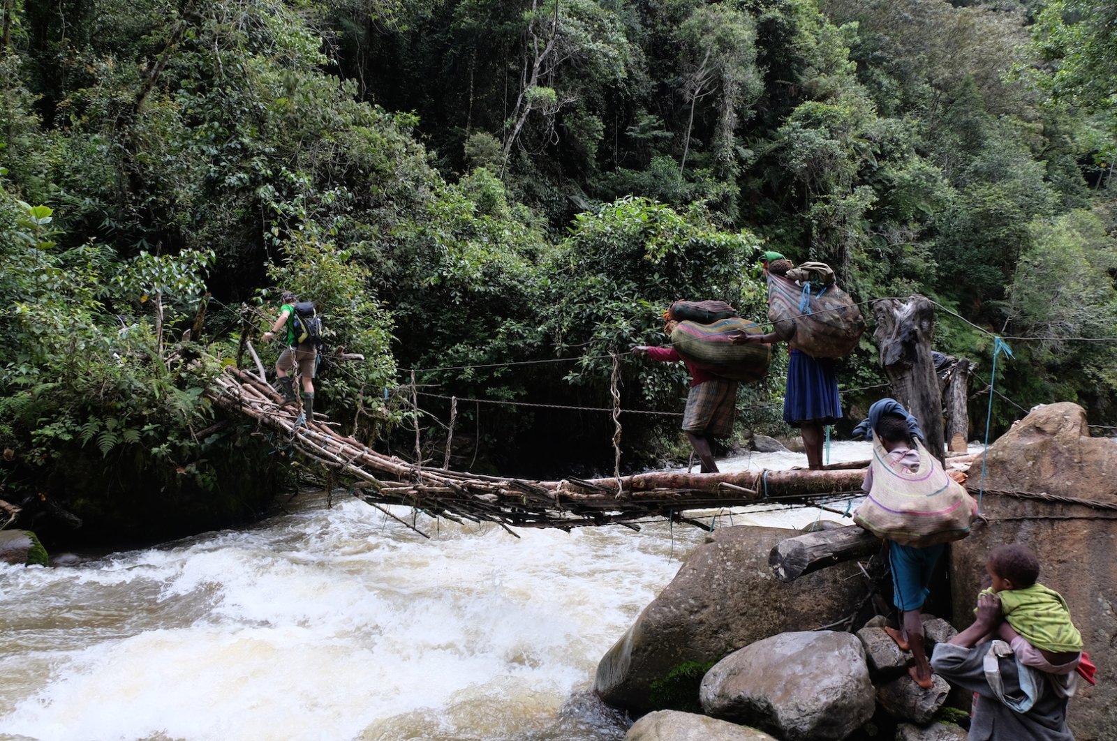 Rini Indyastuti’s porter brings the climbers food and equipment across the Kemabu River in the Intan Jaya Regency, Papua, Indonesia, June 2016. (Photo by Rini Indyastuti)