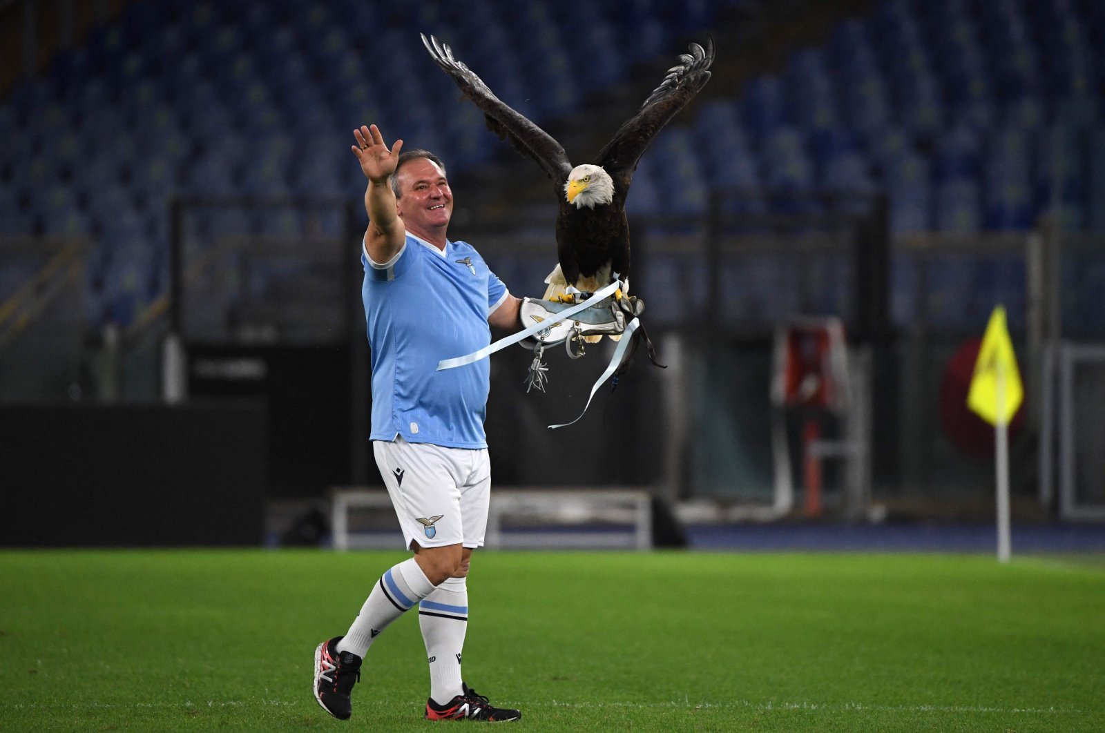 A falconer holds Lazio's mascot eagle "Olimpia" after it flew over the stadium prior to the UEFA Europa League Group E football match between Lazio Rome and Lokomotiv Moscow on Sept. 30, 2021, at the Olympic stadium in Rome. (AFP Photo)