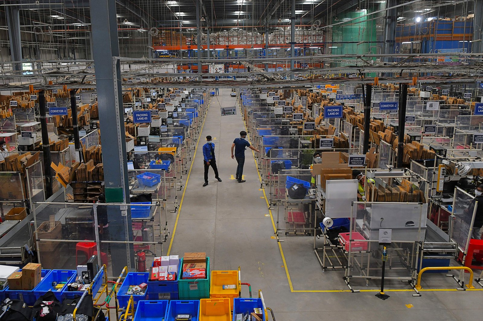 Workers walk in the aisle of a packaging area at the Flipkart fulfillment center in Bangalore, India on Sept. 23, 2021, ahead of the Flipkart Big Billion Days 2021 sale. (AFP Photo)