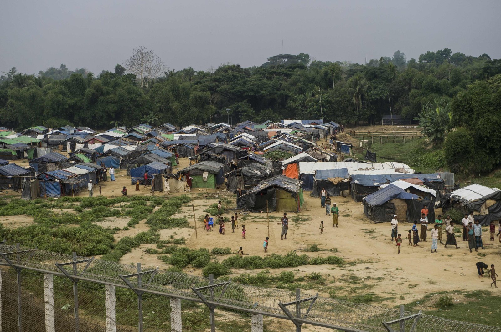 Rohingya refugees gather near their shelters in the "no man's land" behind Myanmar's border lined with barbed wire fences in the Maungdaw district, Rakhine state bordered by Bangladesh, April 25, 2018. (AFP Photo)