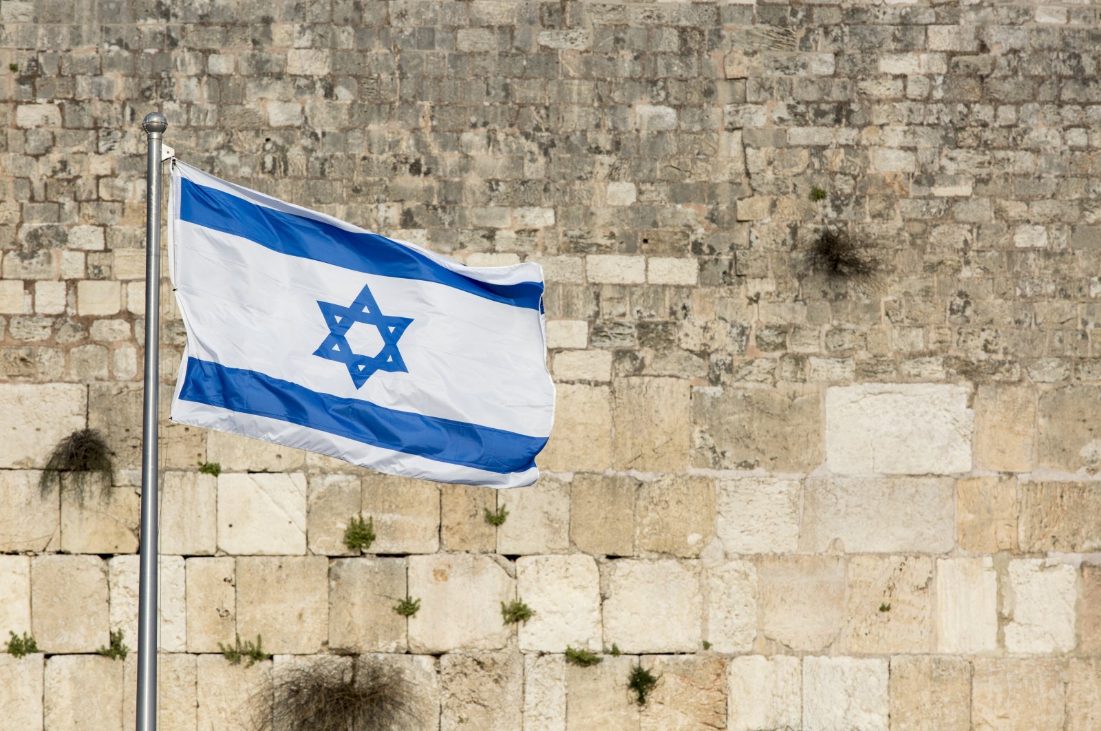 An Israeli flag flies over the Western Wall, in the Old City in East Jerusalem, occupied Palestine. (Getty Images)