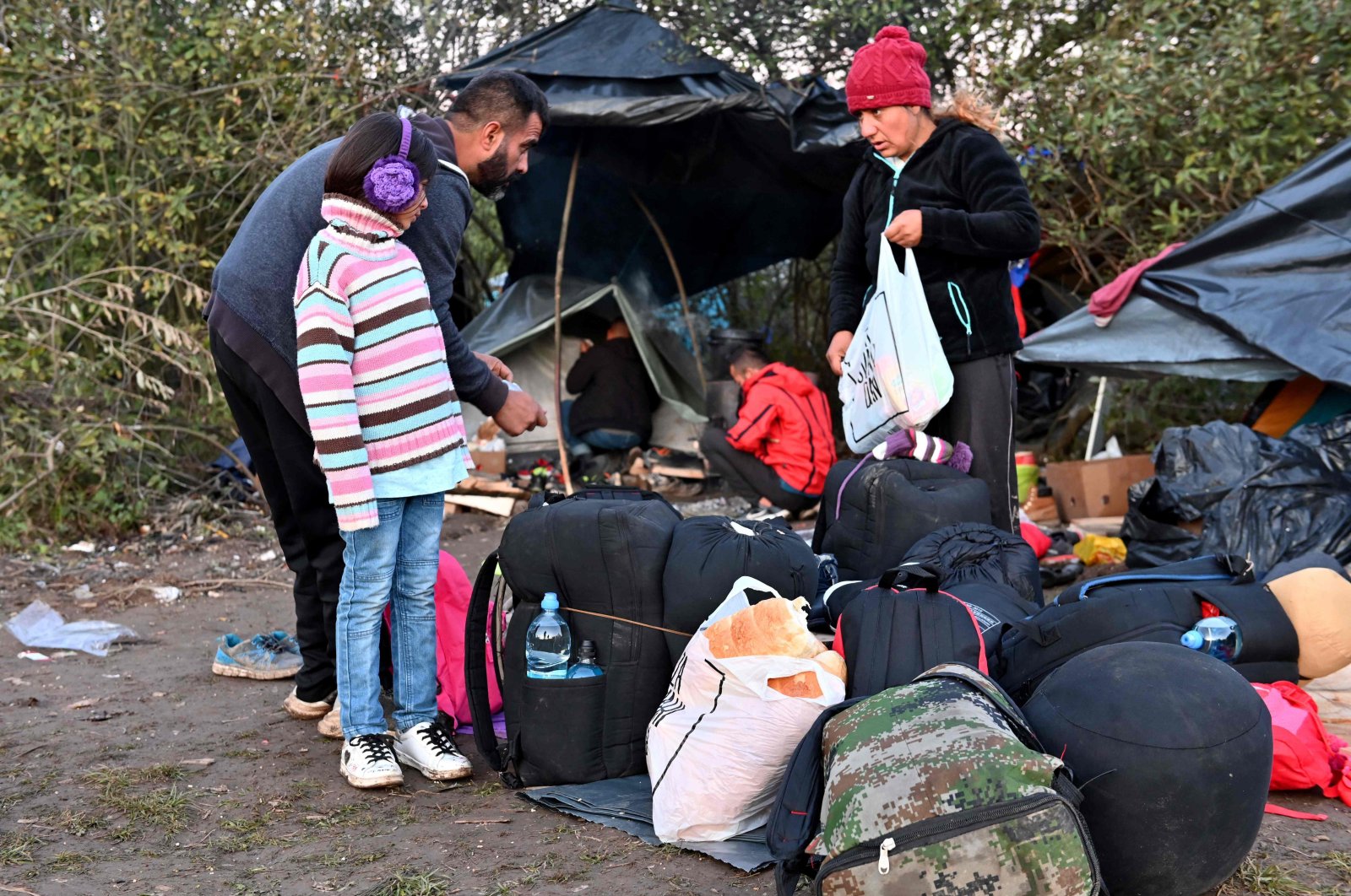 Members of an Afghan family pack their belongings as they prepare to cross the Croatian border near their illegal improvised camp, outside the northern Bosnian border town of Velika Kladusa, Oct. 15, 2021. (AFP Photo)