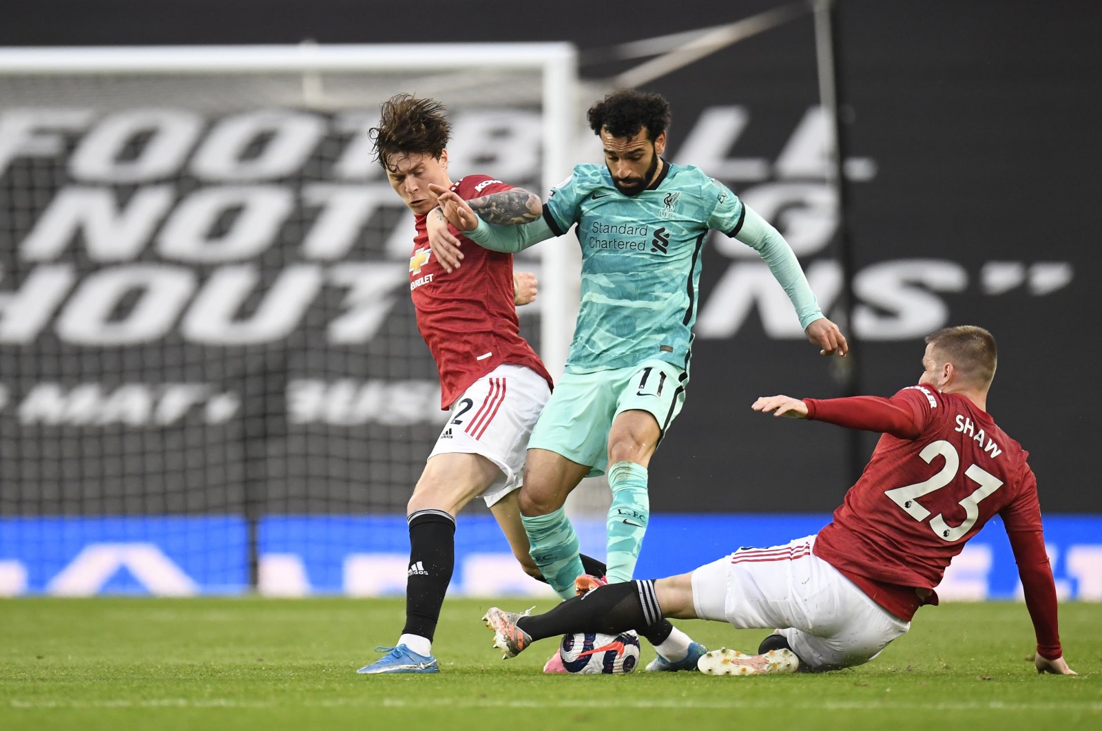 Liverpool's Mohamed Salah (C) duels for the ball with Manchester United's Luke Shaw (R) during a Premier League match at the Old Trafford stadium in Manchester, England, May 13, 2021. (AP Photo)