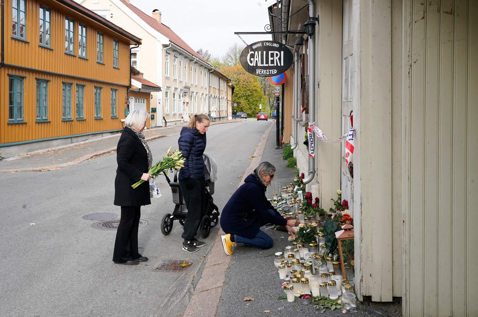 Three students of artist Hanne Merethe Englund, who was one of five victims killed in a bow-and-arrow attack on October 13, lay flowers in front of her house in Kongsberg, Norway, on Oct. 18, 2021. (AFP Photo)