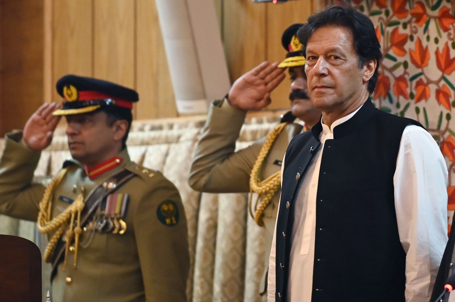 Pakistan's Prime Minister Imran Khan (R) listens to the national anthem as he arrives at the legislative assembly in Muzaffarabad, the capital of Pakistan-controlled Kashmir to mark the country's Independence Day, Aug. 14, 2019. (AFP Photo)